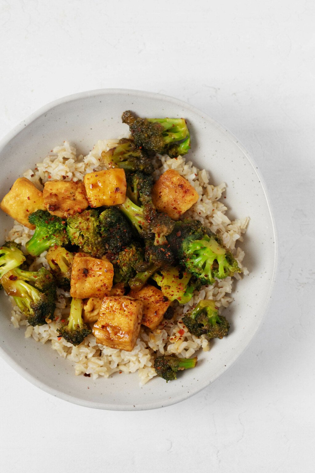 An overhead image of a broccoli tofu stir fry, which has been served over a bed of brown rice.